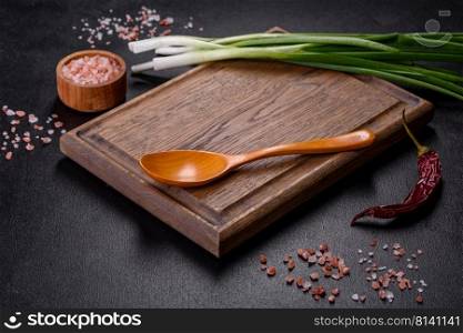 Cut Green onionsχves on a cutting board. Dark wooden background. Top view of spring onions bunch ready to cutting on chopπng board