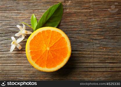 Cut half open orange fruit with orange flower on wooden table