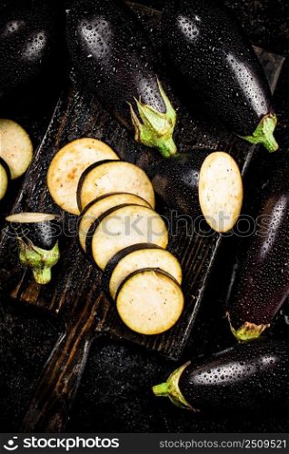 Cut into pieces on a cutting board of eggplant. On a black background. High quality photo. Cut into pieces on a cutting board of eggplant. 