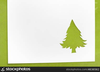 cut paper in fir-tree shape on table. Cut paper in christmas tree shape for christmas card or new year background on green table