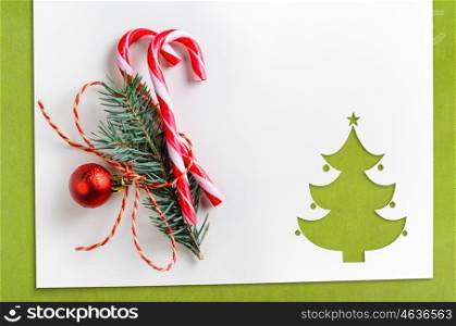 cut paper in fir-tree shape on table. Cut paper in christmas tree shape with decoration for christmas card or new year background on green table