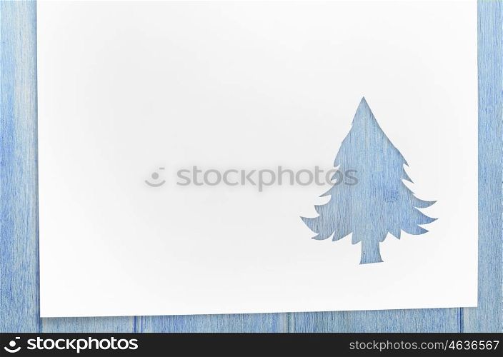 cut paper in fir-tree shape on table. Cut paper in christmas tree shape for christmas card or new year background on wooden table