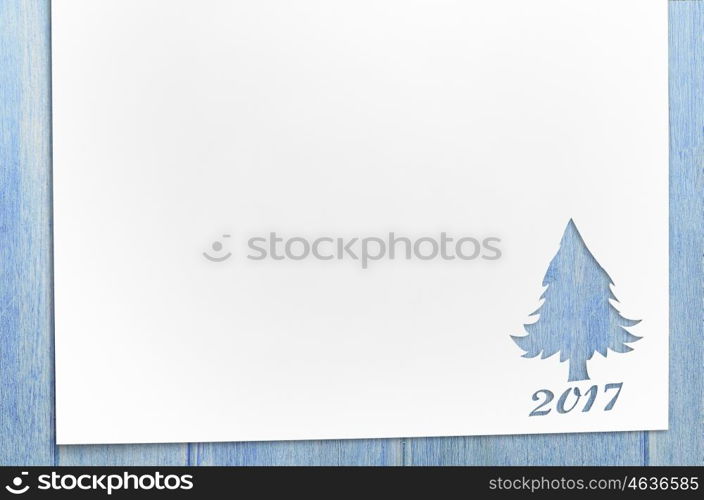 cut paper in fir-tree shape on table. Cut paper in christmas tree shape for christmas card or new year background on wooden table