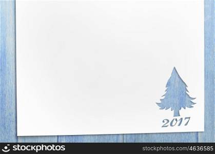 cut paper in fir-tree shape on table. Cut paper in christmas tree shape for christmas card or new year background on wooden table
