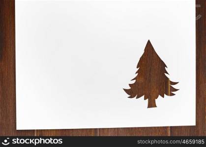 cut paper in fir-tree shape on table. Cut paper in fir-tree shape for christmas card or new year background on wooden table