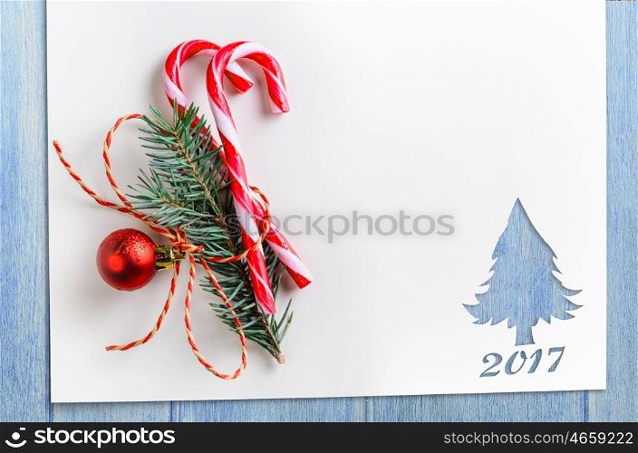 cut paper in fir-tree shape on table. Cut paper in fir-tree shape with decoration for christmas card or new year background on blue table