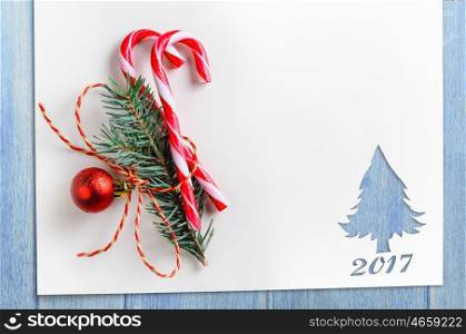 cut paper in fir-tree shape on table. Cut paper in fir-tree shape with decoration for christmas card or new year background on blue table