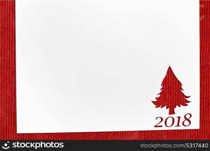 cut paper in fir-tree shape on table. Cut paper in fir-tree shape for christmas card or new year background on red table