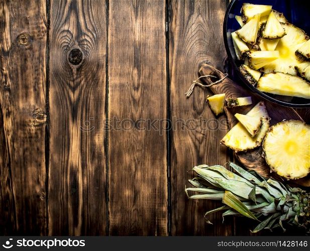 Cut pieces of pineapple . On a wooden table.. Cut pieces of pineapple .
