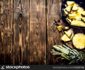 Cut pieces of pineapple . On a wooden table.. Cut pieces of pineapple .