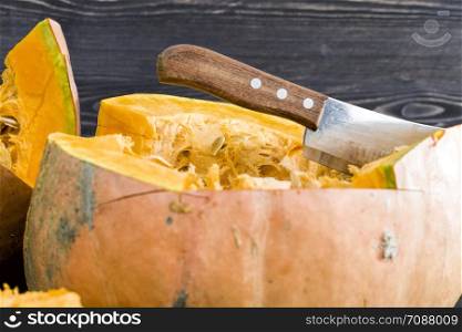 cut pieces of pumpkin orange during cooking for dinner from vegetables, close-up metal cleaver. cut pieces of pumpkin