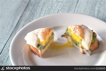 Cut sandwich with guacamole and poached egg