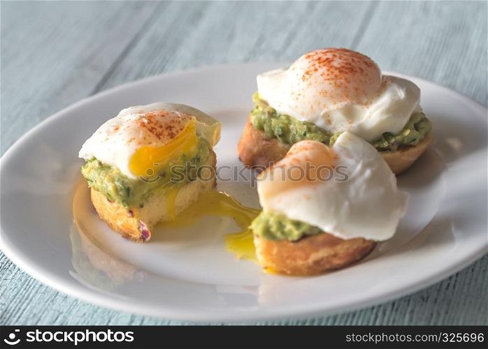 Cut sandwich with guacamole and poached egg