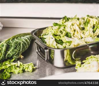 Cut Savoy cabbage in metal bowl on kitchen table