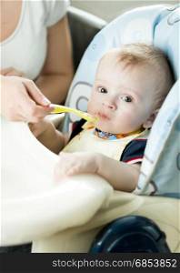 Cute 9 month baby boy eating from spoon