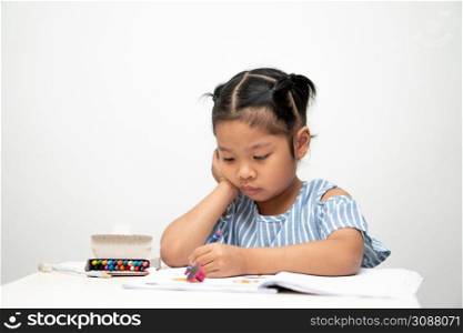 Cute adorable asian ethnic kid girl holding color pen drawing and painting on the table, She is Having Fun and Laughs. Concept of learn and enjoy creative hobby, child development.