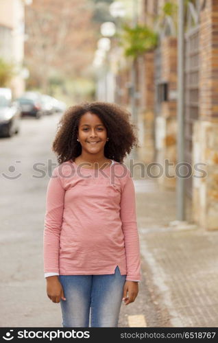 Cute African American girl in the street with afro hair. Cute African American girl smiling in the street with afro hair