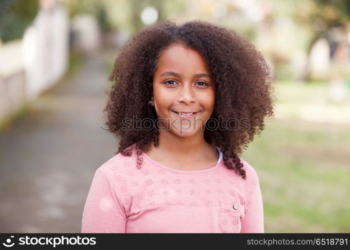 Cute African American girl in the street with afro hair. Cute African American girl smiling in the street with afro hair