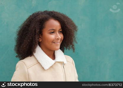 Cute African American girl smiling with afro hair on a green background