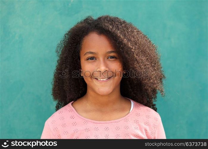 Cute African American girl smiling with afro hair on a green background
