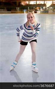 cute and blond girl with shorts and a nice sweater smiling and skating over white