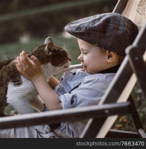 Cute and little boy hugging a cat