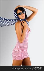 cute and sensual brunette wearing a red beach dress and blue foulard with white dot