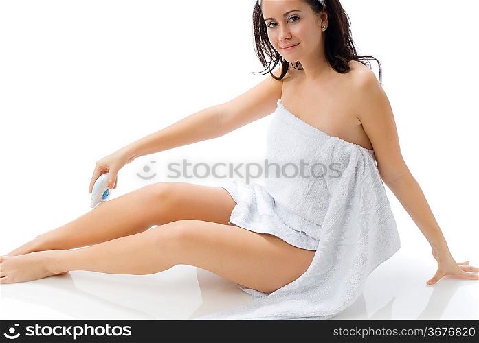 cute and young brunette dressing white towel shaving her legs
