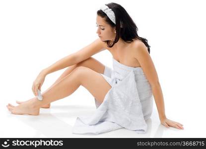 cute and young brunette dressing white towel shaving her legs and making face