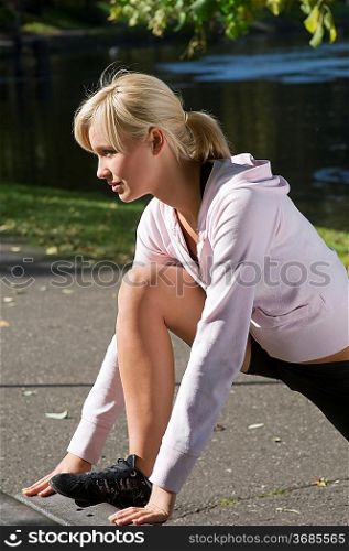 cute and young woman in sport wear making gym exercise in park