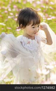 cute asian children girl in nature flowers field. children girl in nature flowers field