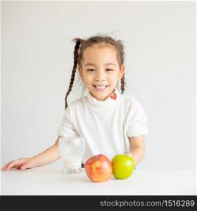 Cute Asian little girl express happy emotion and enjoy after drink milk with white background.