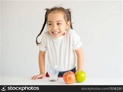 Cute Asian little girl express happy emotion and enjoy after drink milk with white background.