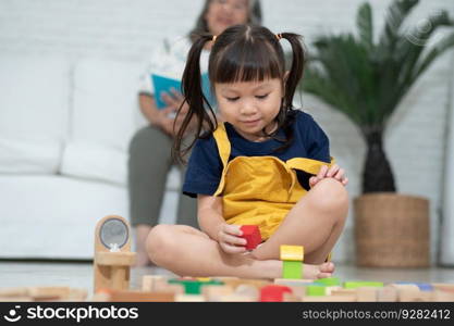 Cute asian little girl playing with colorful toy blocks, Kids play with educational toys at kindergarten or daycare. Creative playing of kid development concept, Toddler kid in nursery.