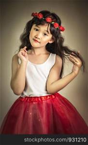 Cute asian little girl with wreath of flowers on her head. portrait of asian little girl