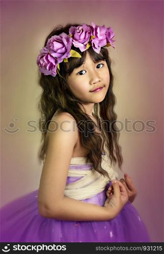 Cute asian little girl with wreath of flowers on her head. portrait of asian little girl