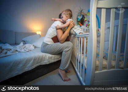 Cute baby boy got scared at night at hugging young caring mother
