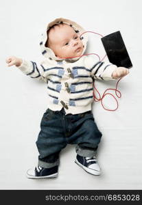 Cute baby boy listening music with earphones