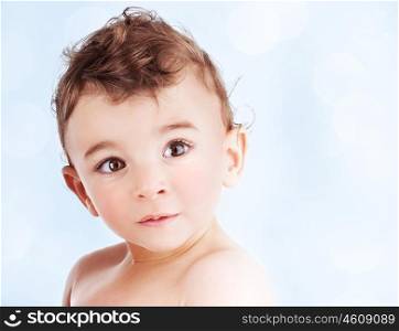 Cute baby boy over blue background, portrait with a copy space of an adorable sweet child, nice kid model indoor, healthy lifestyle, happy childhood concept