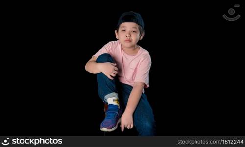 cute baby face dressed in a pink shirt sit with in a studio. Isolated on dark background.Close up portrait