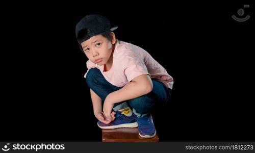 cute baby face dressed in a pink shirt sit with in a studio. Isolated on dark background.Close up portrait