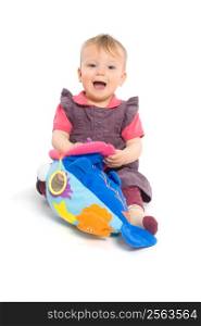 Cute baby girl (1 year old) sitting on floor playing with stuffed animal toy. Isolated on white, smiling. Toys are offically property released.
