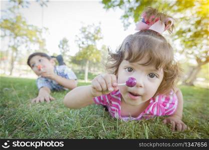 Cute Baby Girl and Brother with Lollipops in the Park.