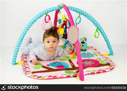 cute baby girld playing in an activity gym