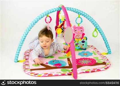 cute baby girld playing in an activity gym