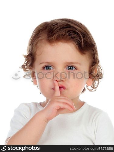 Cute baby has put forefinger to lips as sign of silence, isolated on a white background