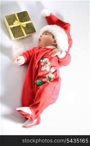 Cute baby in santa wear and gold gift on white