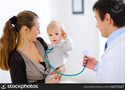 Cute baby on mamas hand playing with stethoscope &#xA;