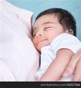 Cute baby sleeping on mothers hands, carefree and happy childhood, lovely new family, peace and relaxation concept