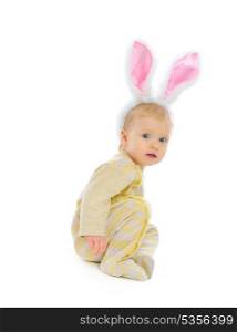 Cute baby with rabbit ears sitting on floor isolated on white